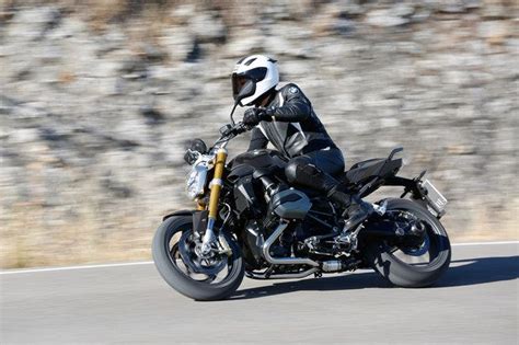 man riding  motorcycle   road    rocky hillside   sunny day