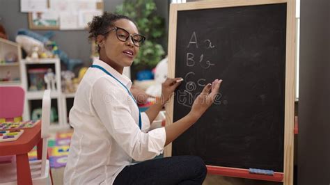 African American Woman Teacher Smiling Confident Writing On Blackboard