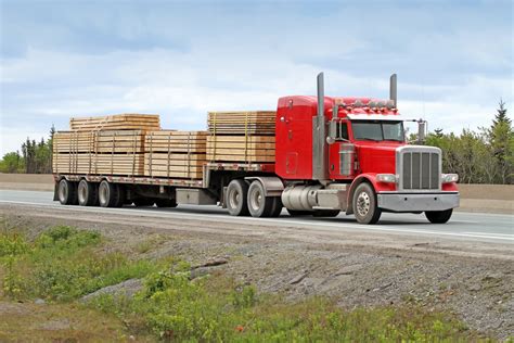 semi flatbed truck hauling  load  lumber   construction site mexicom logistics