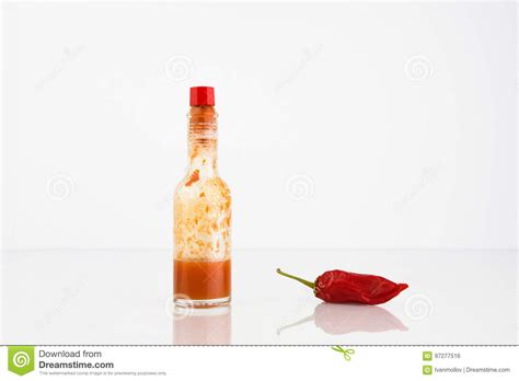 Roodgloeiend Chili Pepper And Bottle Of Chili Sauce Stock Foto Image