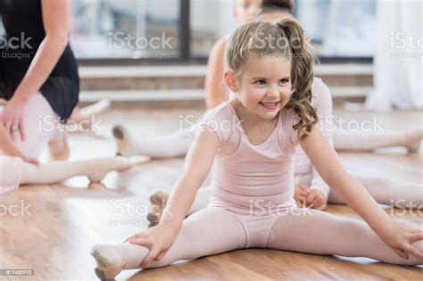 niña extiende las piernas en clase de ballet foto de stock y más banco