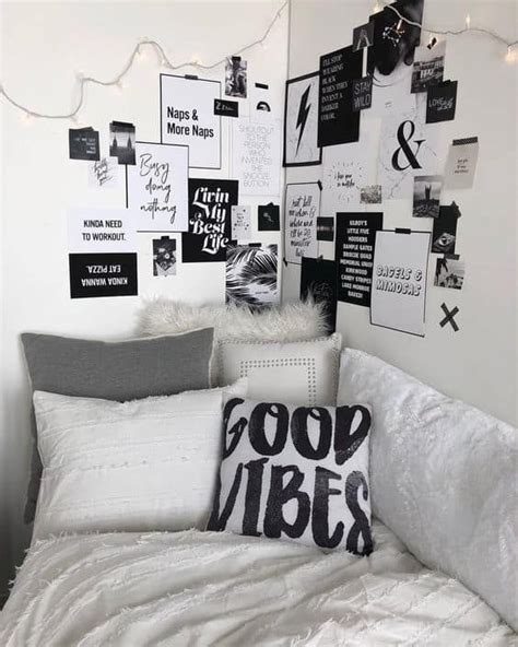 A White Bed Topped With Lots Of Pillows Next To A Wall Covered In Black