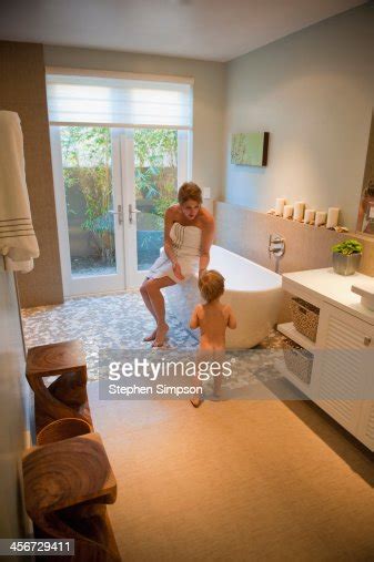 mom trying to coax her small son into the bath tub photo getty images