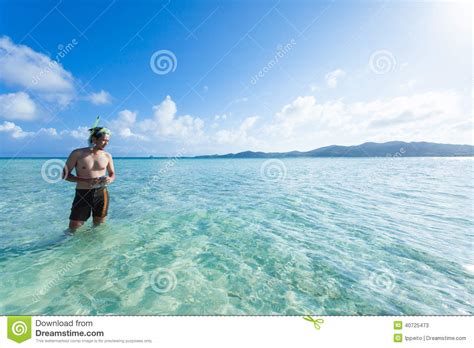 man standing in clear tropical beach water okinawa japan
