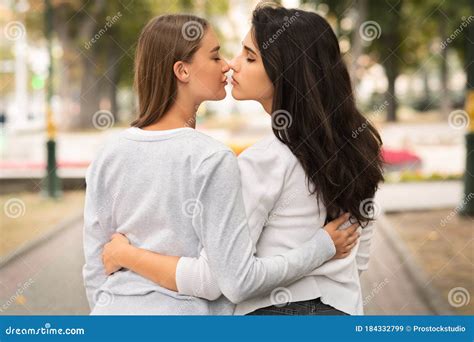 Lesbian Couple Of Girls Kissing Having Date Outdoor Back View Stock