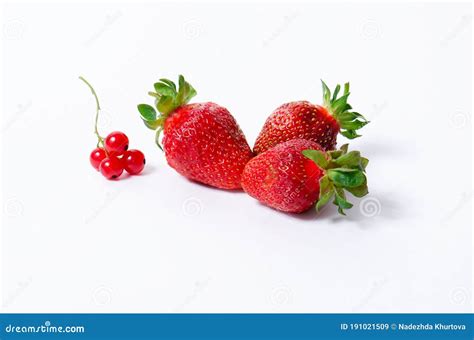 drie aardbeien met kleine borsten van rode aalbessen op een witte achtergrond stock afbeelding