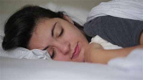 pensive shot of girl laying down in bed closing her eyes and falling asleep stock footage