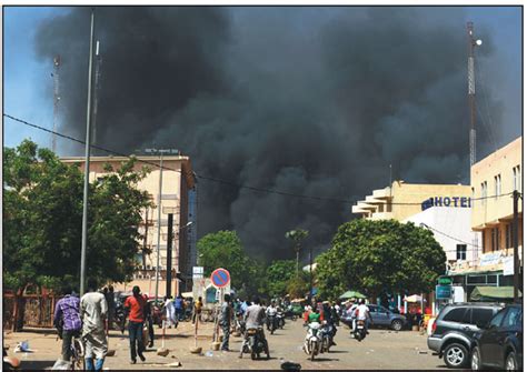 people watch as black smoke rises after the capital of