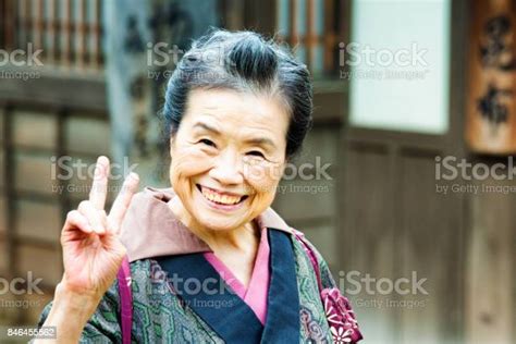 Old Japanese Lady In Traditional Clothing Portrait Smiling And Doing