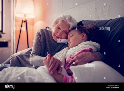 Grey Haired Granny Hugging Her Sick Cute Girl Falling Asleep Stock
