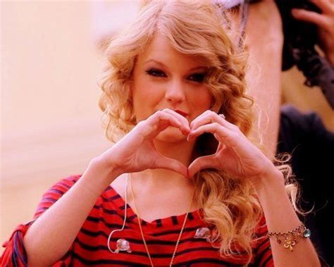 post picture of taylor swift making a heart with her hands