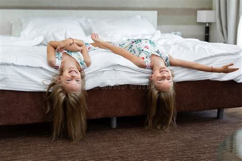 two twin sisters are lying on the bed upside down stock image image