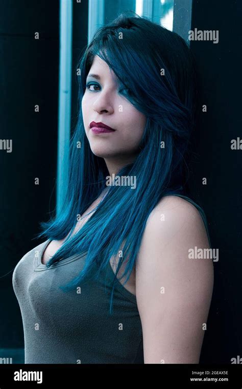 Young Woman With Blue Hair Standing By The Bus Stop Looking Towards