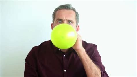 handsome man blowing   yellow balloon   explodes stock