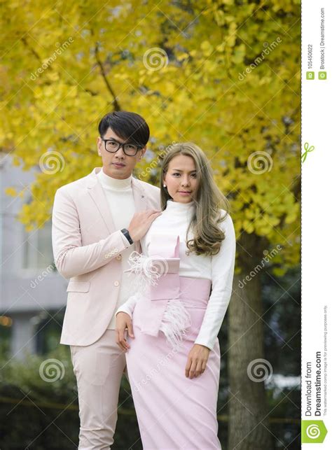 japanese couple in love stand together under autumn trees