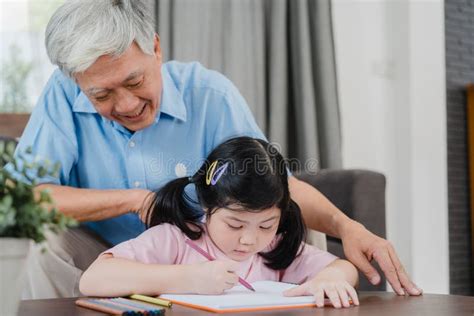 Asian Grandfather Talking With Granddaughter At Home Senior Chinese