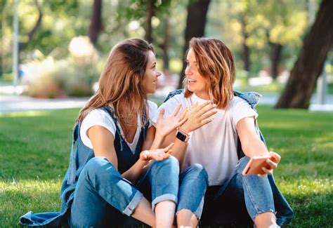 Candid Friends Seated At The Park Talking To Each Other Stock Image