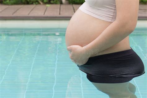 Pregnant Woman Hands Holding Belly On Swimming Pool Stock Image