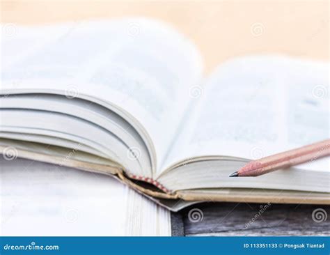 open textbook stacked   wooden table selective focus stock image