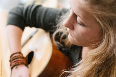 teenage girl playing a guitar by stocksy contributor jacqui miller