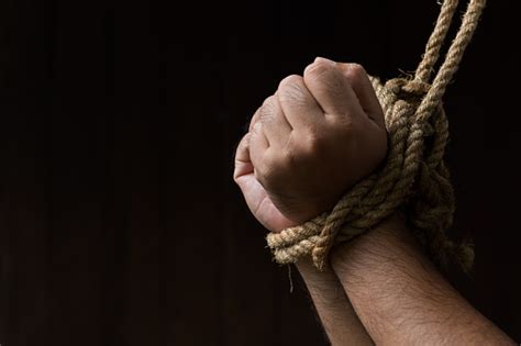 Hands Are Tied With Rope On The Black Background Loss Of Freedom And