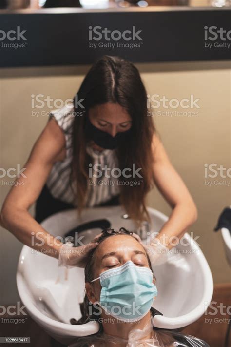 Hairdresser Washing Womans Hair Both Wearing Mouth Nose Masks Stock