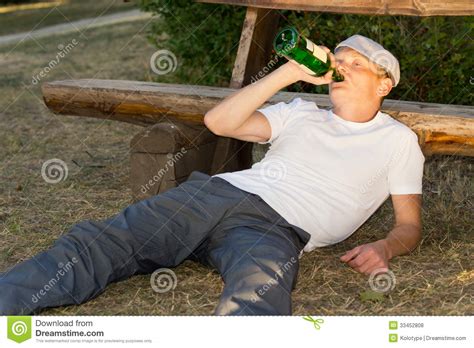 Alcoholic Relaxing In A Park With His Liquor Royalty Free