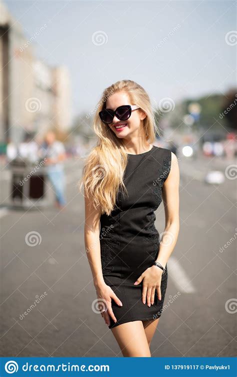 Happy Blonde Model Wearing Black Dress And Sunglasses