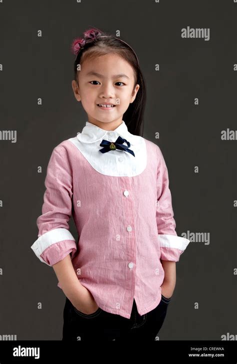 5 year old chinese girl smiling dressed in pink shirt and jeans