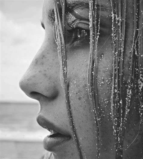 A Close Up Of A Person With Water On Their Face And Hair Blowing In The
