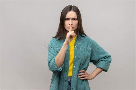 Serious Woman Showing Silence Gesture With Finger On Her Mouth Asking