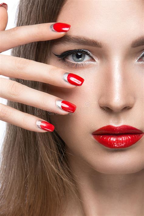 face of a woman with beautiful dark nails and red lips
