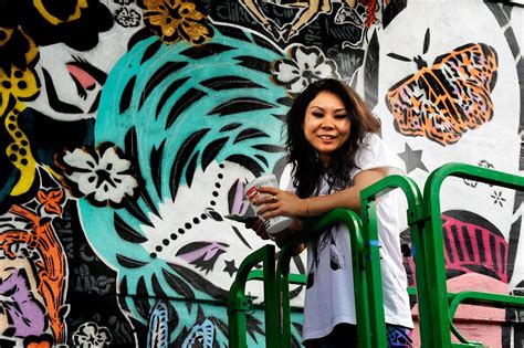 lady aiko acclaimed street artist in front of her work street