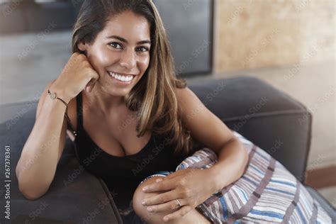 Joyful Lovely Feminine Young Tanned Hispanic Woman Lying Sofa Hugging