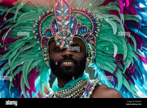 Black African Looking Man Dressed In Bright Green Feathers And