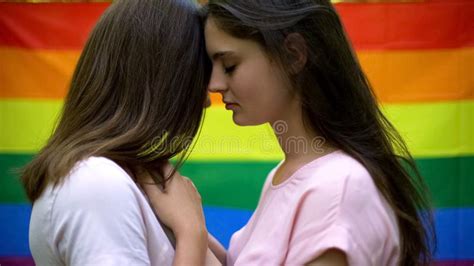 Ładni lesbians ściska czule tęczy flaga na tle tej samej płci