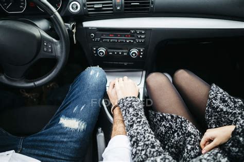 close up of couple driving in car holding hands — travel adults