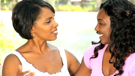close up loving african american mother daughter spending time together sitting garden bench