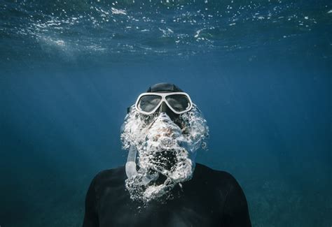 person with snorkle and goggles swimming underwater photo free greece image on unsplash