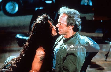 Sonia Braga Leaning In To Kiss Clint Eastwood In A Scene From The