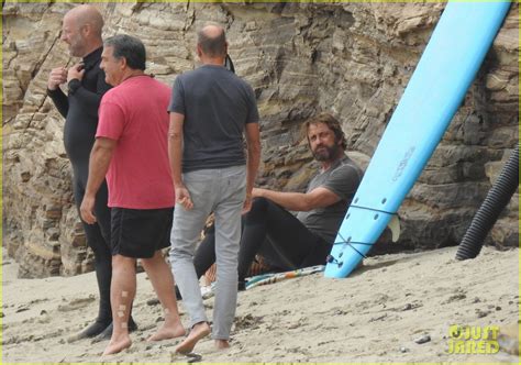 gerard butler puts on his skintight wetsuit for a day of surfing photo
