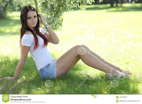 menina erótica com a mini saia na grama verde imagem de