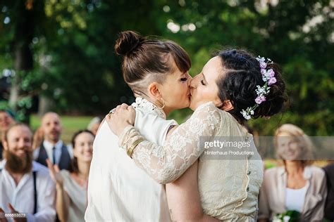 lesbian couple kissing at their wedding ceremony high res