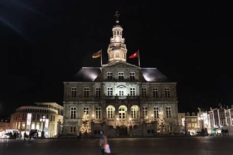 large building lit   night  people walking