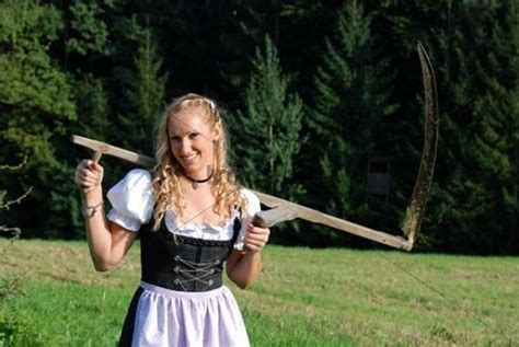 Farm Girl With A Scythe Wearing A Dirndl A Traditional German Or