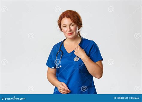 Portrait Of Cute Redhead Female Doctor Nurse Or Physician In Blue