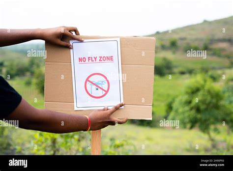 close  shot  hands pasting  fly zone sign  board  drone restricted area  safety
