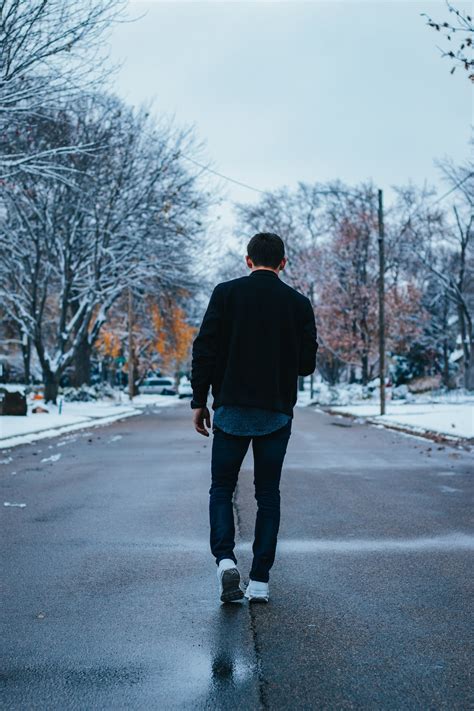 man walking  road  bare trees  daytime photo  human