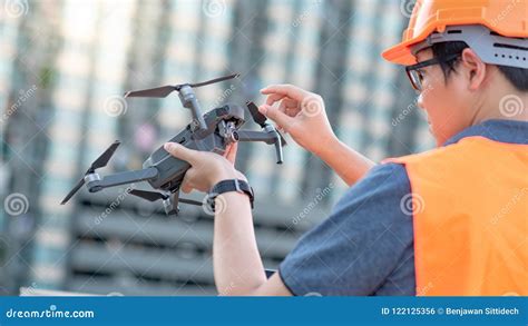 young asian engineer holding drone  construction site stock photo image  orange