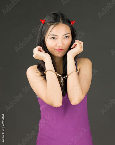 Devil Side Of A Young Asian Woman With Handcuffs And Looking Sad Buy